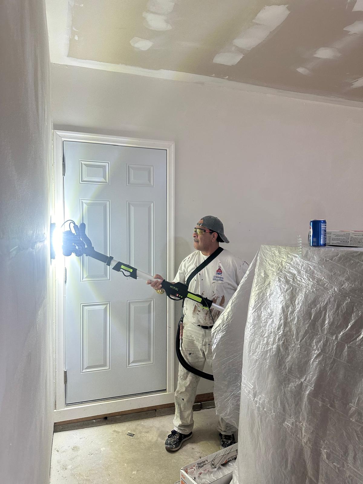 Roy Painting Services crew member spray-painting an interior door in Chester County, PA